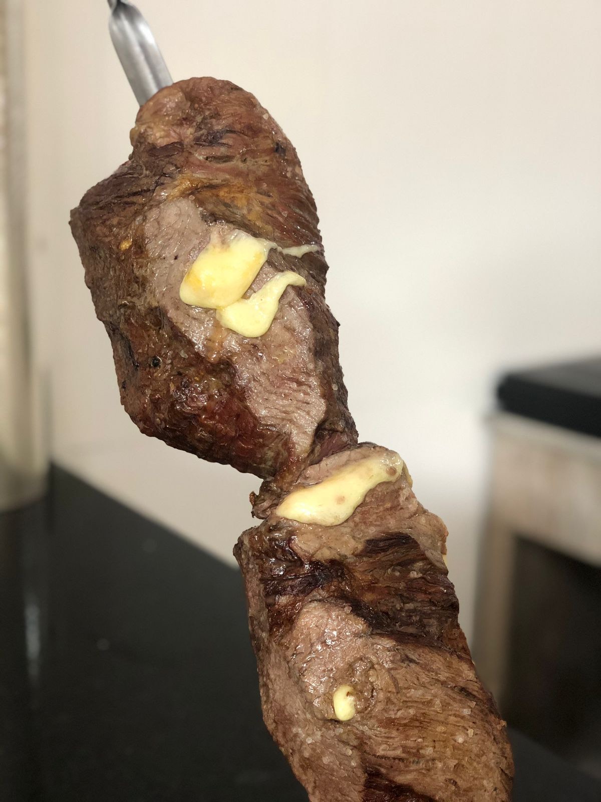 Carne, linguiça e batata frita em uma mesa de madeira